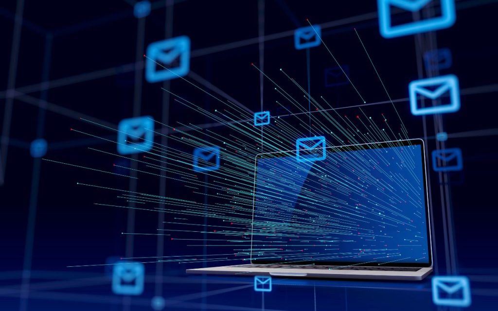 The power of email marketing - a laptop with digital envelope icons and light streaks represents the concept of sending or receiving multiple emails in a virtual environment.