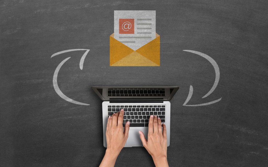 Hands typing on a laptop keyboard with an email icon above and two curved arrows on a chalkboard background, representing email communication.