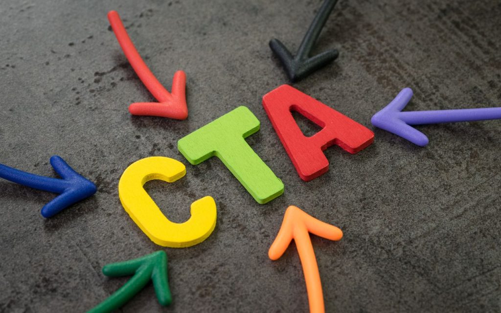 Colorful letters spelling "CTA" are arranged on a gray surface, surrounded by multicolored arrows pointing toward the letters.