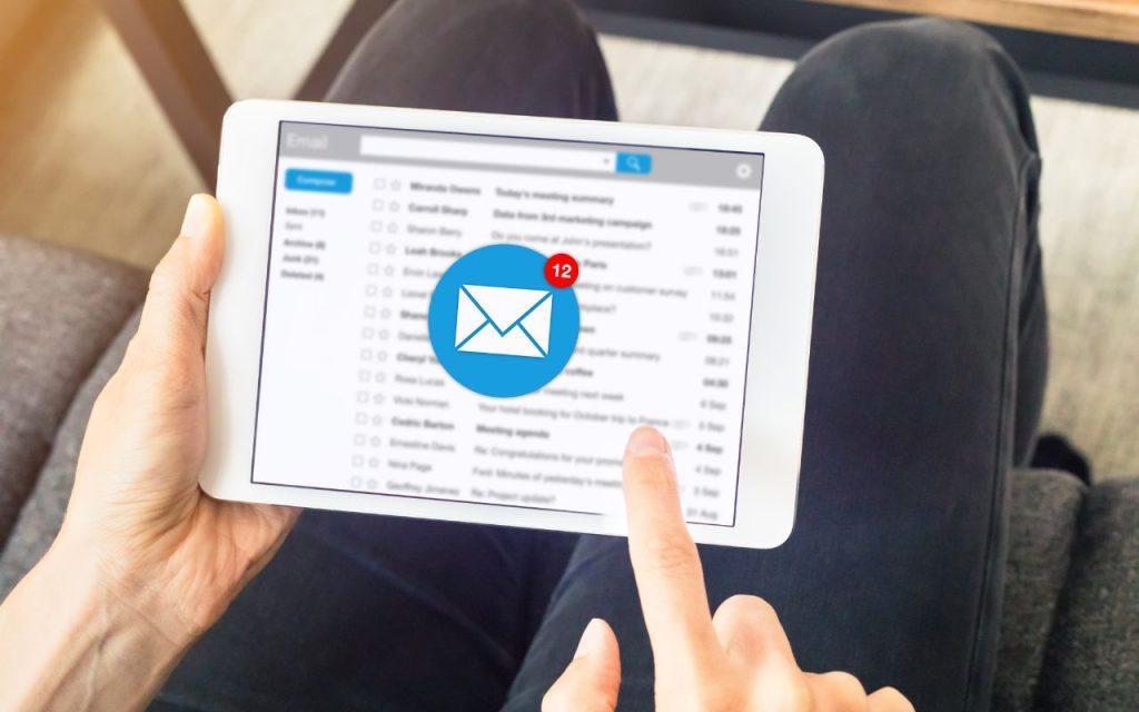 A person holding a tablet views an email inbox with a notification for 12 new unread messages.