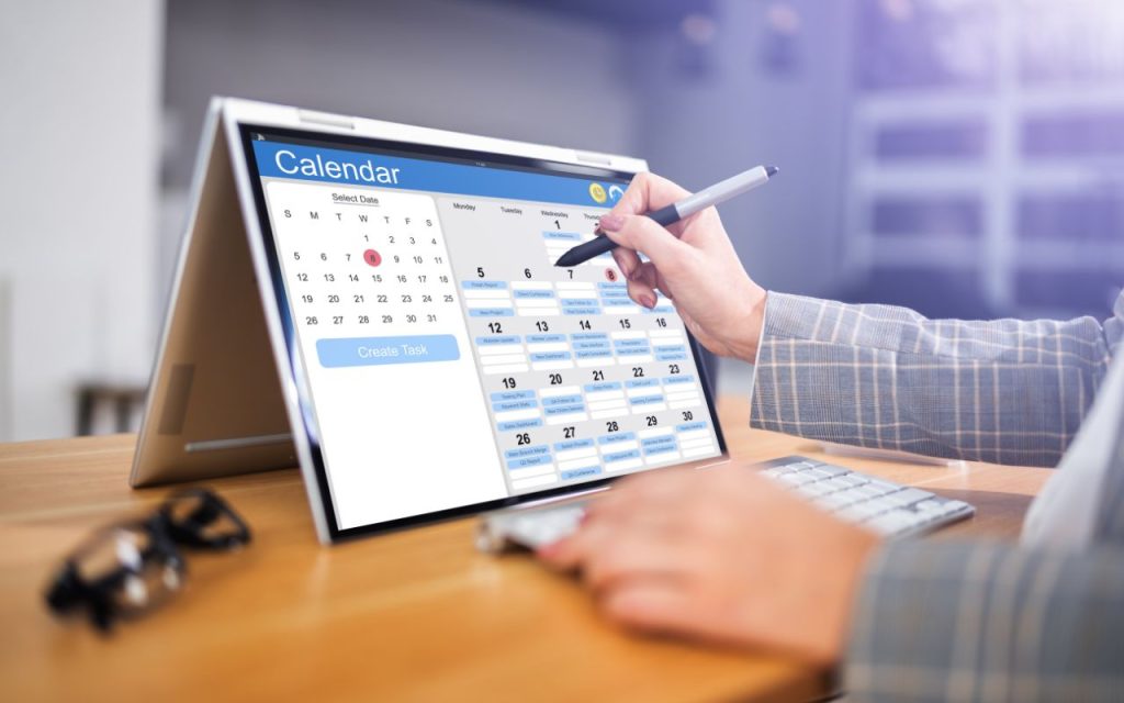 Lead follow-up - real results from small tweaks - Person using a stylus to select dates and create tasks on a digital calendar displayed on a touchscreen laptop.
