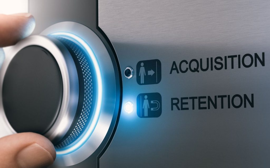 2026 Marketing Trends: The New Local Loyalty — Retention Outperforms Reach. A hand turns a glowing knob on a metallic panel with labeled options: "Acquisition" and "Retention." The light indicates selection of "Retention.