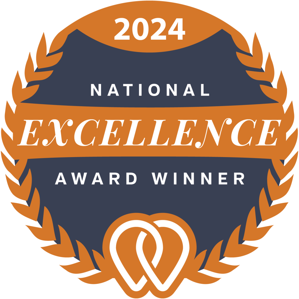 badge-upcity-excellence-award-2024-full A 2024 National Excellence Award Winner badge with orange laurel design, navy background, and a stylized pretzel shape at the bottom.